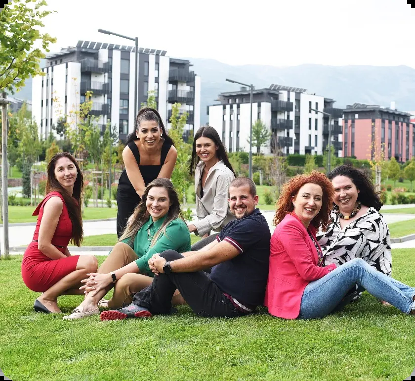 7 young people at Amusnet sitting outside in the grass