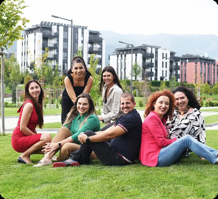 7 young people at Amusnet sitting outside in the grass